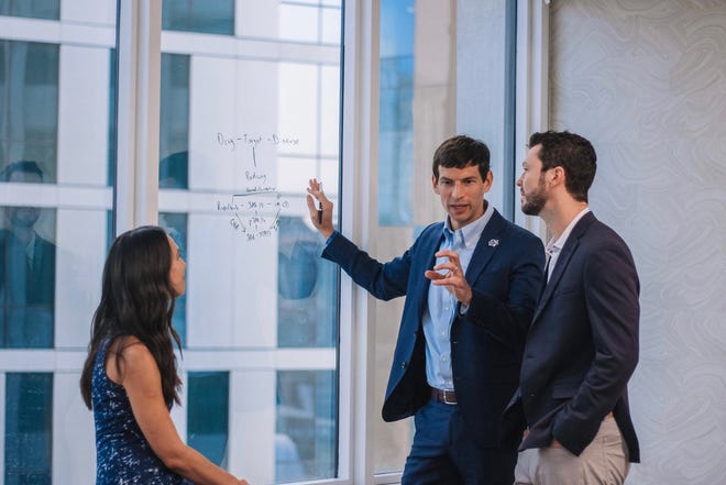 Drs.  David Fajgenbaum and Grant Mitchell (middle and right), co-founders of Every Cure, with their colleague Tracey Sikora.